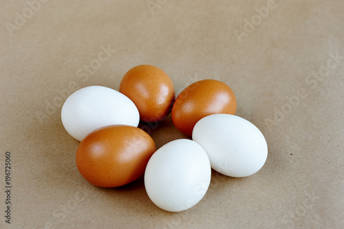 raw white and brown eggs on a craft background