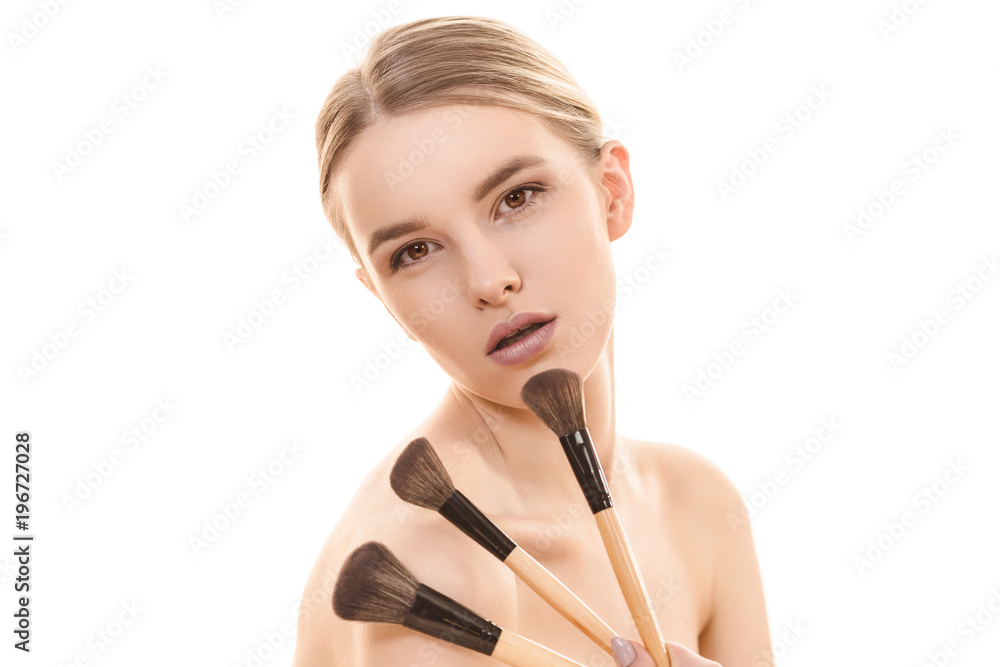The pretty woman with cosmetic brushes on the white background The pretty woman with cosmetic brushes on the white background