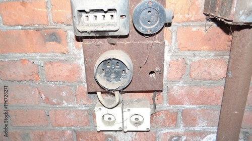 The electrical outlet on a brick wall.