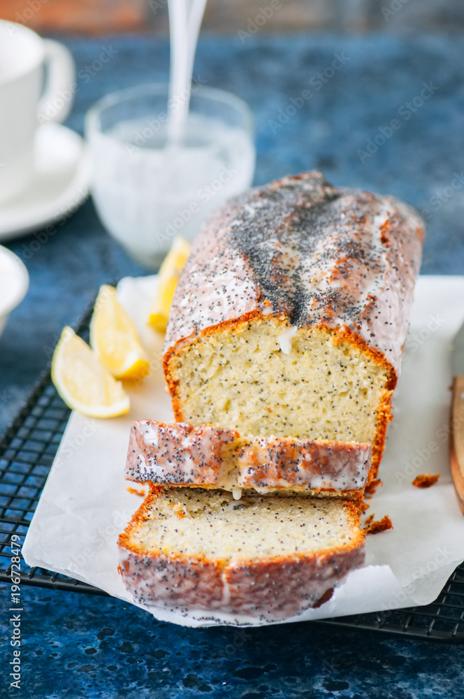 Homemade lemon poppy seed pound cake on a wire rack. Blue stone background. Close up. Homemade lemon poppy seed pound cake on a wire rack. Blue stone background. Close up.