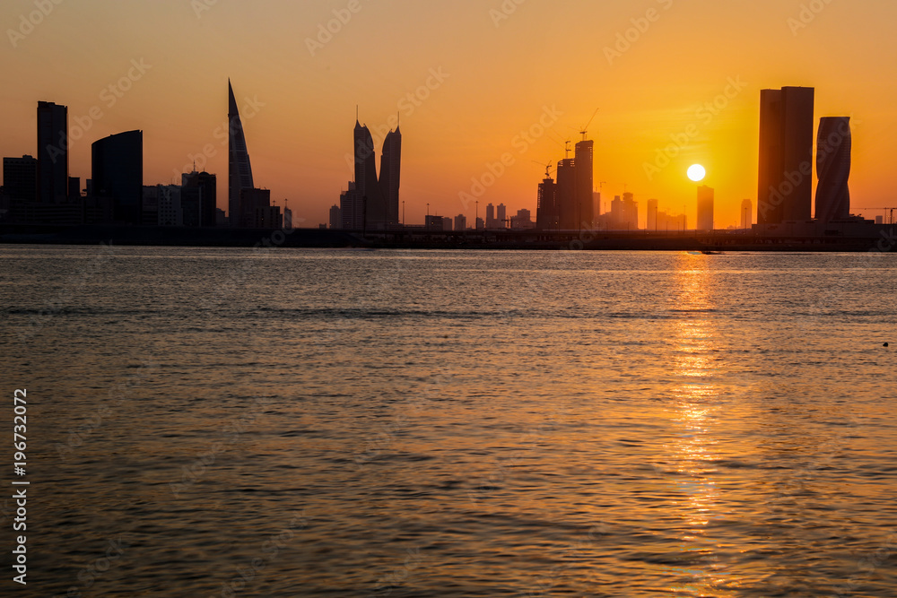 A golden sunset behind a city skyline
