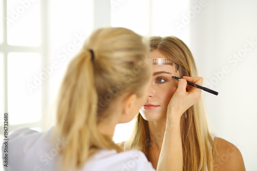Permanent Makeup For Eyebrows. Beautiful Woman With Thick Brows In Beauty Salon. Beautician Doing Eyebrow Tattooing For Female Face. Beauty Procedure