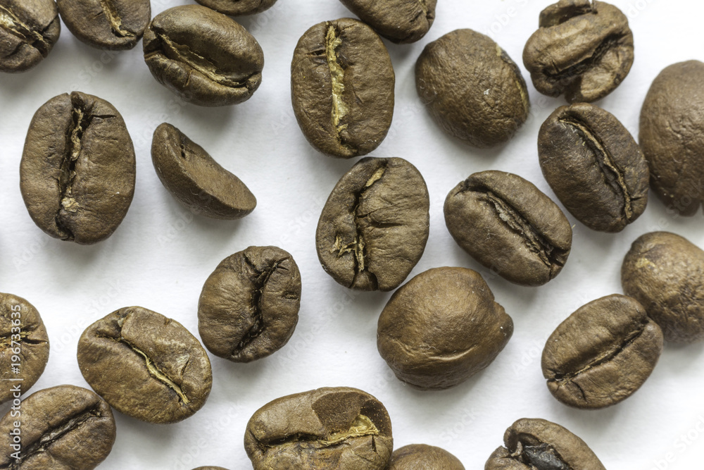 Roasted coffee beans. Different shapes and different shades of brown. On a white background. Photo for the site about food, drinks, health, business. Roasted coffee beans. Different shapes and different shades of brown. On a white background. Photo for the site about food, drinks, health, business.