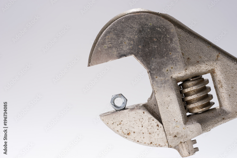 Old monkey wrench and little bolt nut isolated Old monkey wrench and little bolt nut isolated