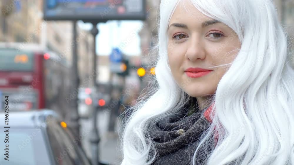 Funny woman with white wig smiles in the city Funny woman with white wig smiles in the city