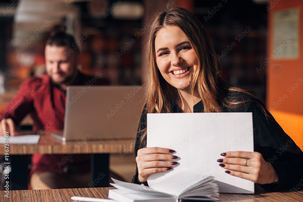 businesswoman with documents in her hands smiling at the camera