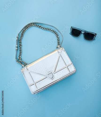  Silver bag with black glasses on a blue background