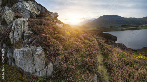 Beautiful vibrant sunrise landscape over Cregennen Lakes with Cadair Idris in background in Snowdonia photo