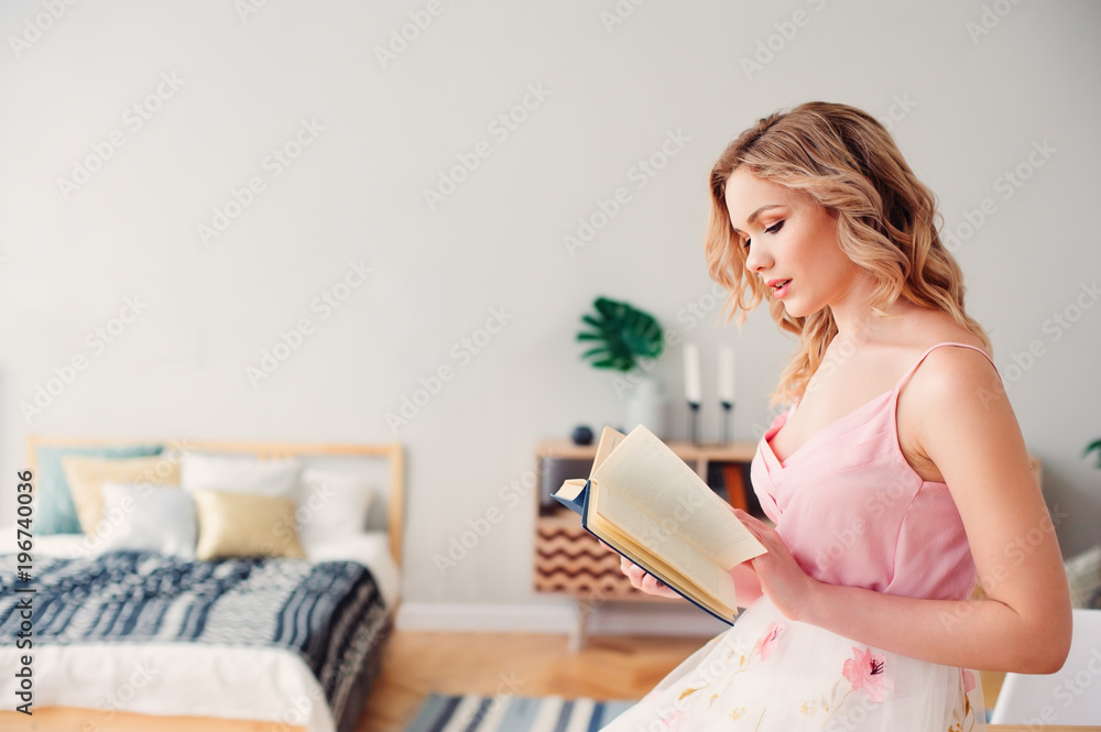 young beautiful woman reading book at home in cozy weekend morning, wearing trendy spring skirt and top. young beautiful woman reading book at home in cozy weekend morning, wearing trendy spring skirt and top.