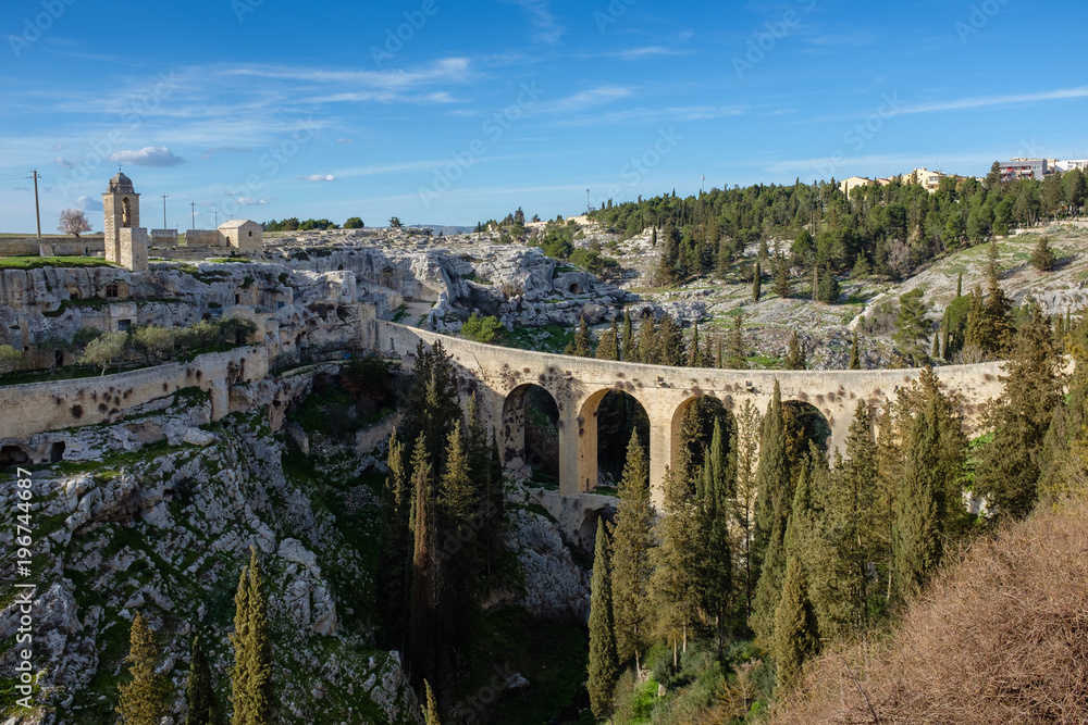 Canyon of Gravina with the old aqueduct stone bridge. Apulia region, Italy.