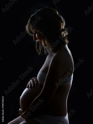 Silhouette of a pregnant woman on black background