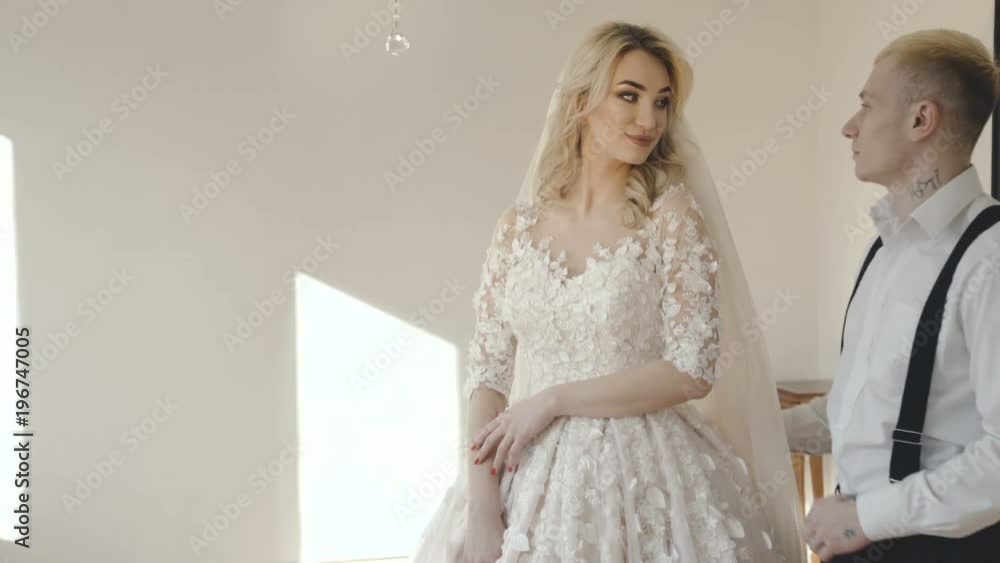 Happy wedding couple caresses at window in room Happy wedding couple caresses at window in room