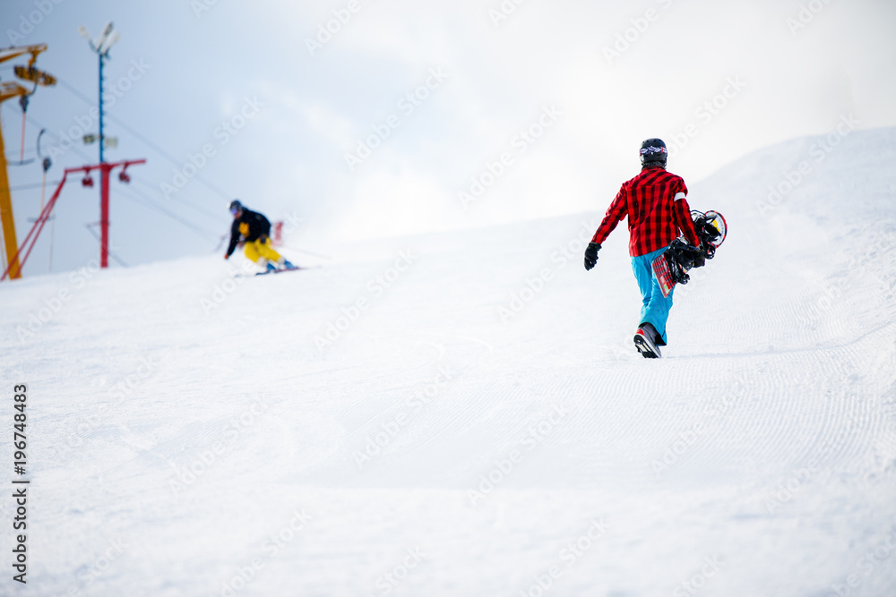 Photo of walking snowboarders in winter park