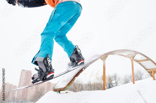 Image from bottom of sportive man skiing on snowboard with springboard