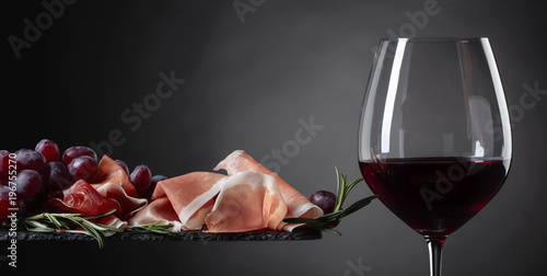 Prosciutto with rosemary and glass of red wine.