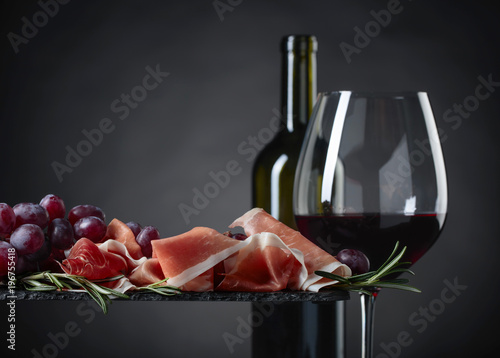 Prosciutto with rosemary and glass of red wine.