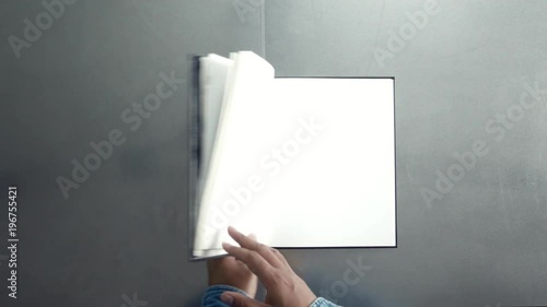 man turning pages of book, magazine with empty white pages