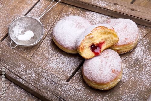 Traditional Polish donuts on wooden background.  Tasty doughnuts with jam.