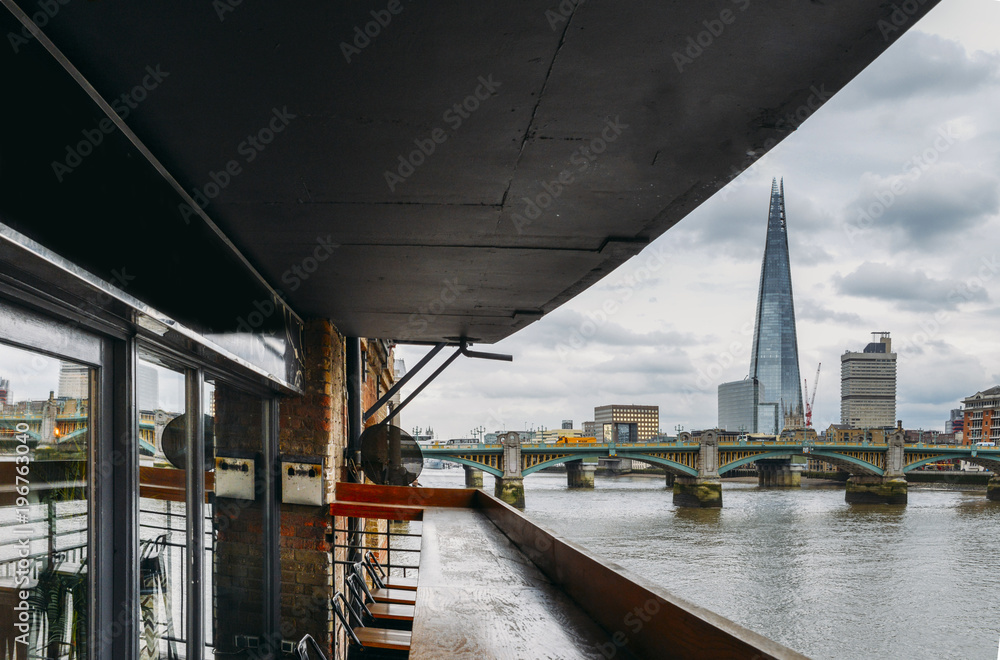 London skyline including the Shard and Southwark Bridge on the River Thames as seen from a comfortable terrace. London skyline including the Shard and Southwark Bridge on the River Thames as seen from a comfortable terrace.