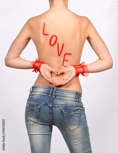 Canvas Print A young semi nude girl has her back turned to the camera