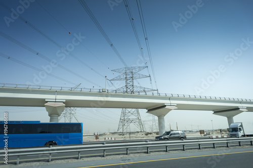 Highway and viaduct under the blue sky. tourist bus on the road against the electric poles