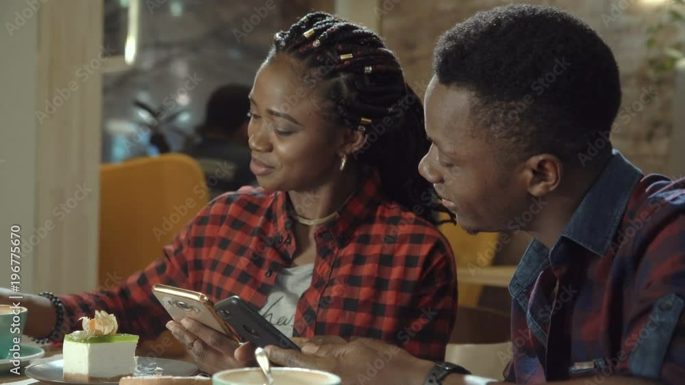Attractive young black couple in a cafeteria enjoying cups of coffee ...