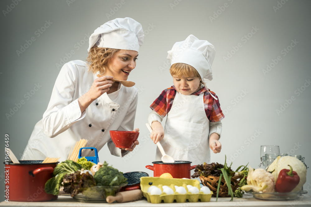 Chef and assistant near kitchen equipment and food products Chef and assistant near kitchen equipment and food products
