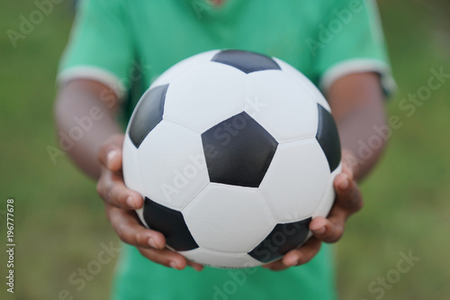 Soccer player with ball in his hand, Classic soccer ball on childs hand © sutthinon602