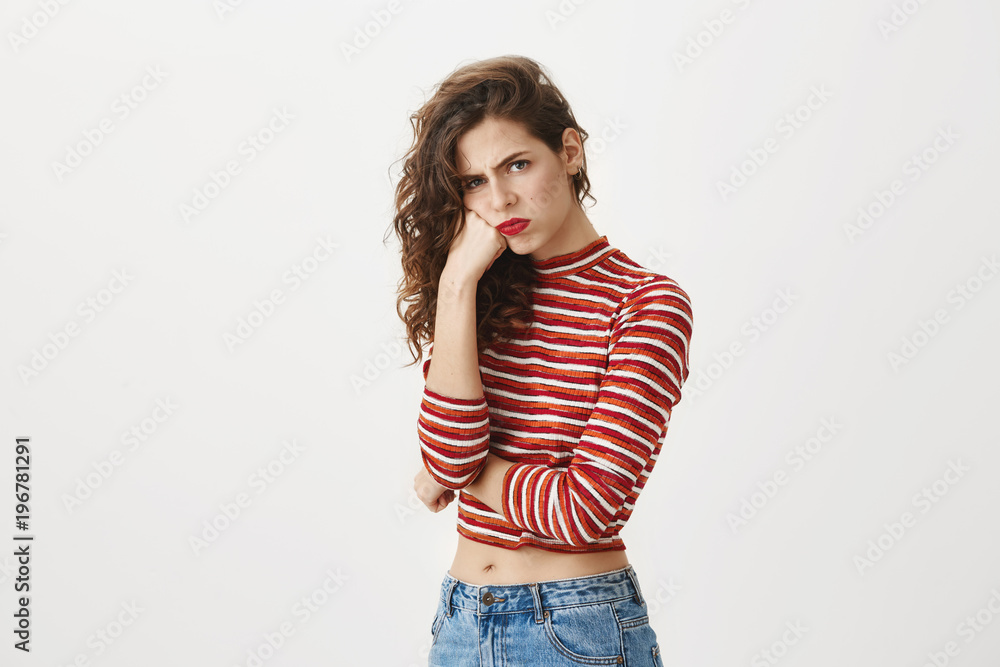 Someday you will pay for my suffering. Studio portrait of attractive female student leaning on fist and looking with angry offended expression at camera, being jealous or mad at person. Someday you will pay for my suffering. Studio portrait of attractive female student leaning on fist and looking with angry offended expression at camera, being jealous or mad at person.