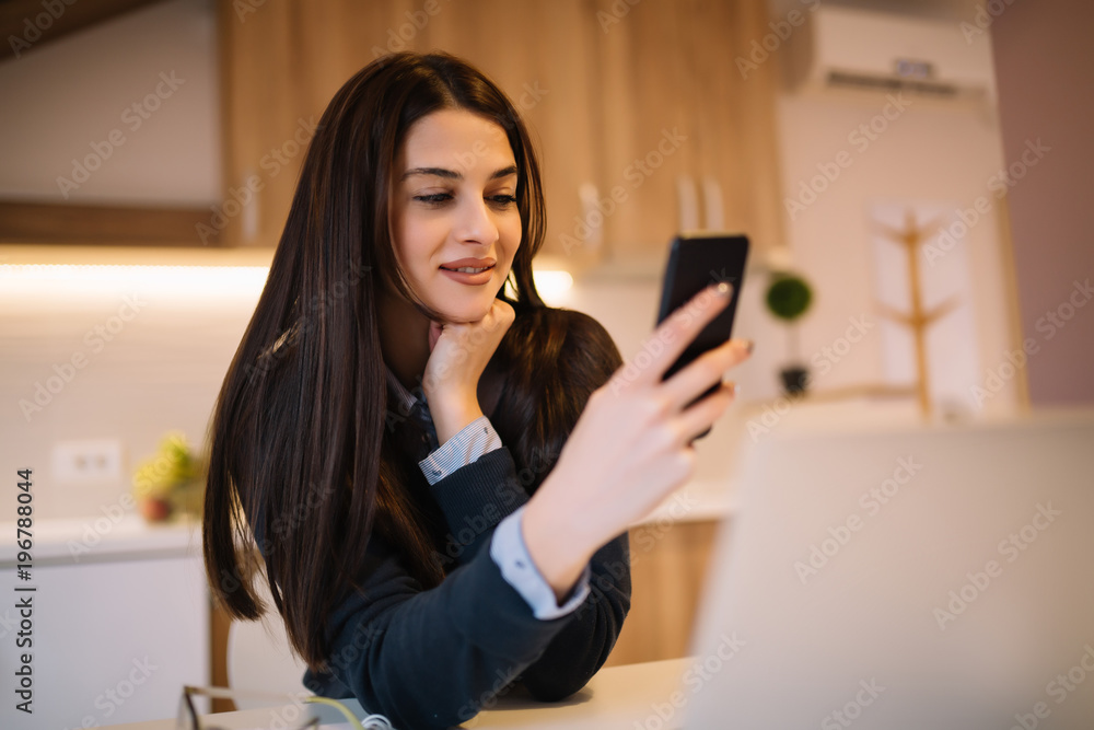 Happy woman working using multiple devices on a desk at home Happy woman working using multiple devices on a desk at home