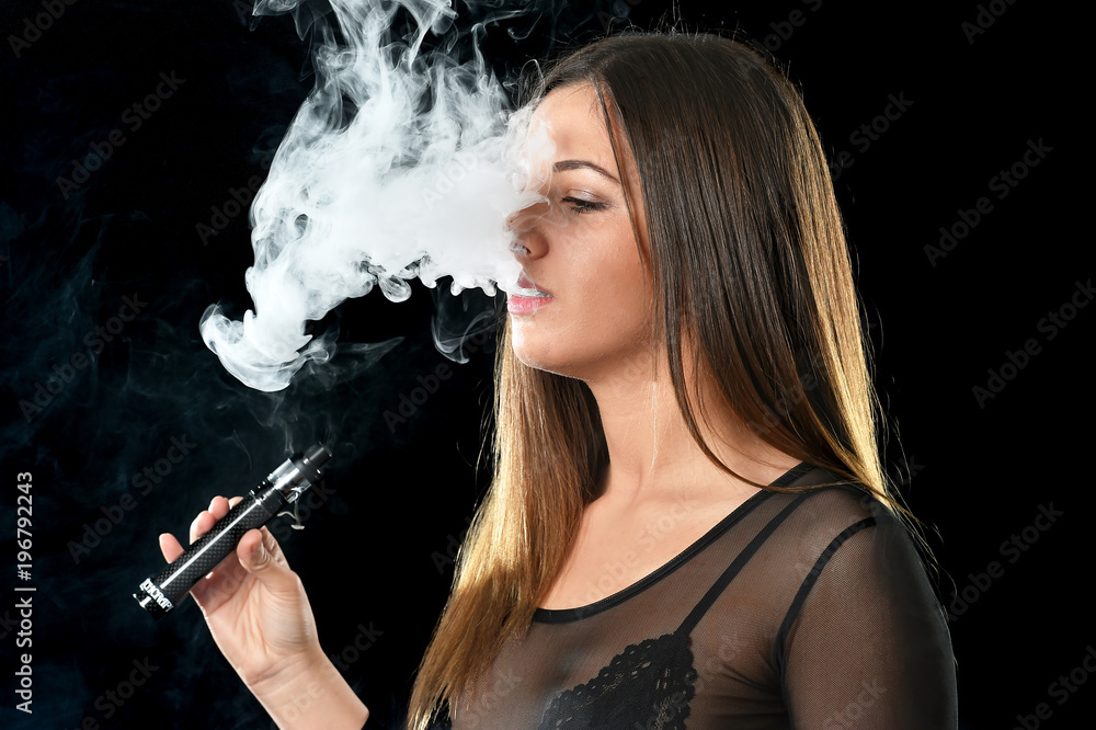 Obraz premium Young woman smoke E cigarette