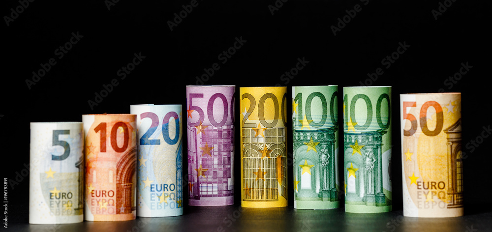 Several hundred euro banknotes stacked by value.Rolls Euro bankn Several hundred euro banknotes stacked by value.Rolls Euro bankn