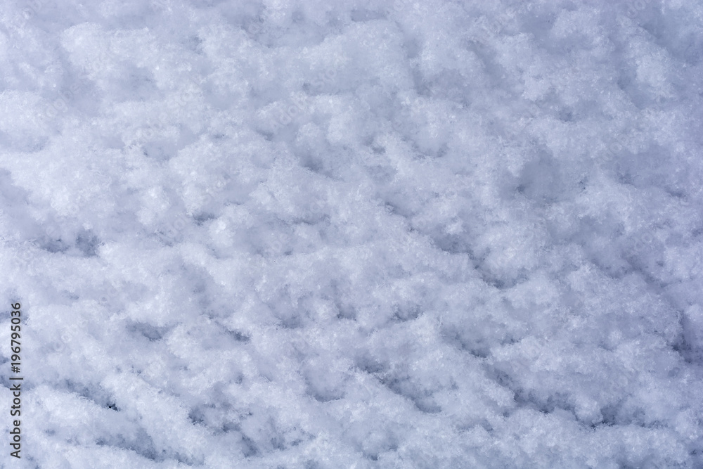 Von Wind und Schnee geformter weißer Hintergrund aus Schneekristallen
