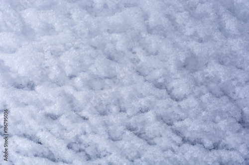 Von Wind und Schnee geformter wei  er Hintergrund aus Schneekristallen