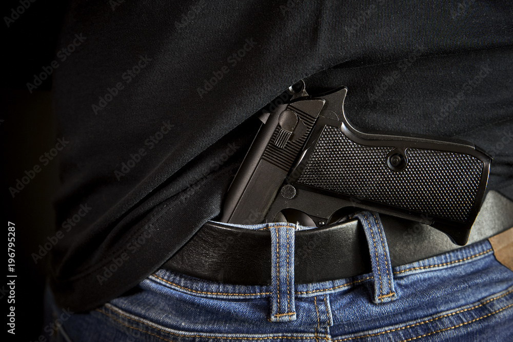 Hidden gun back side to man in blue jeans Hidden gun back side to man in blue jeans