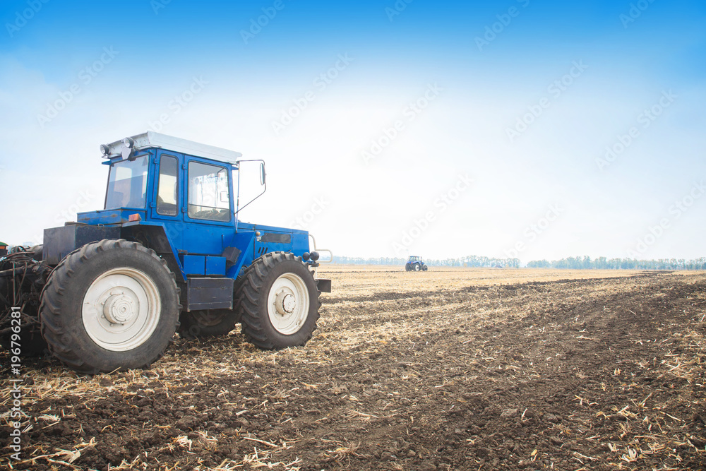 Old blue tractor in a empty field. Agricultural machinery, field work. Old blue tractor in a empty field. Agricultural machinery, field work.