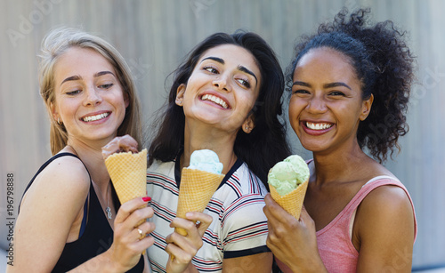 Fotografia, Obraz Happy girlfriends standing together outdoors, holding a ice-cream