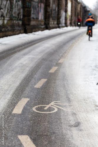 A snow-capped bike path and a cyclist