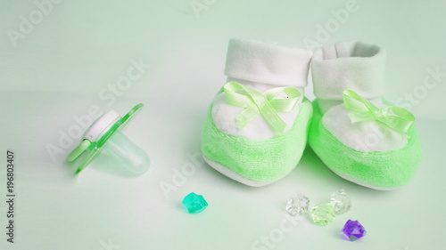 card "waiting for a miracle". bootees, multi-colored rhinestones, children's pacifier. green background