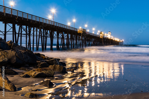 The Oceanside, California fishing pier with lights at dawn. 