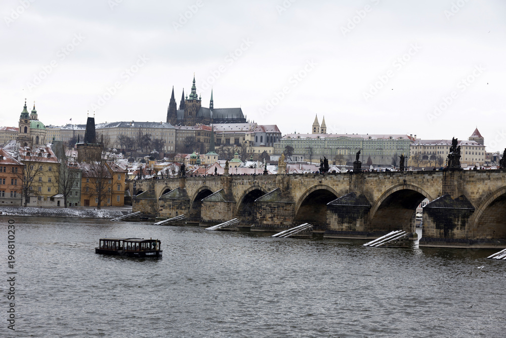 Fototapeta premium Snowy Prague Lesser Town with gothic Castle above River Vltava, Czech republic