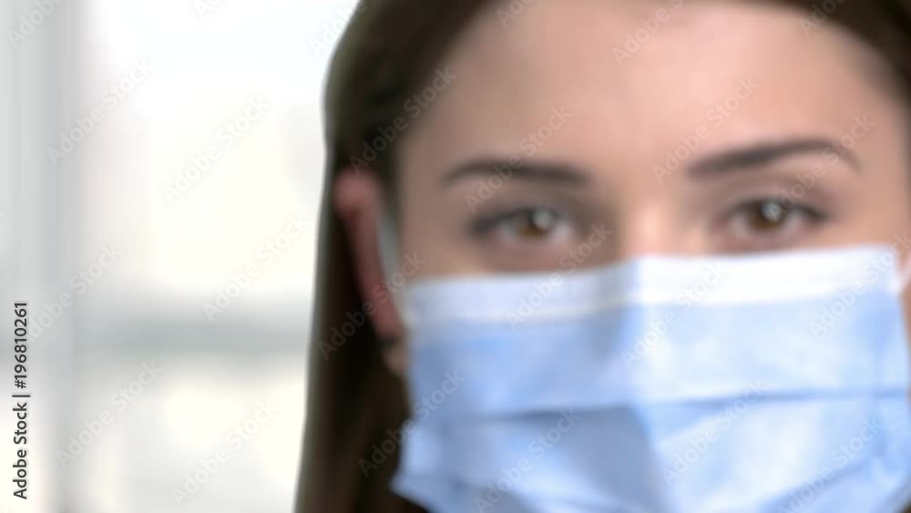 Close up syringe in nurse hand. Professional nurse in surgical mask with injection close up. Injection with transparent liquid.