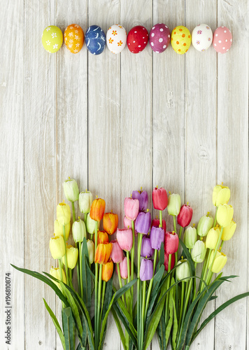 Fototapeta Naklejka Na Ścianę i Meble -  Colorful Easter eggs and tulips on wood