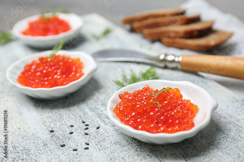 Little plates with delicious red caviar on table