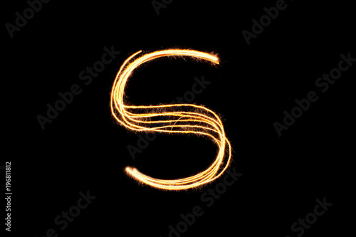 Light painting alphabet S on black back ground isolate.