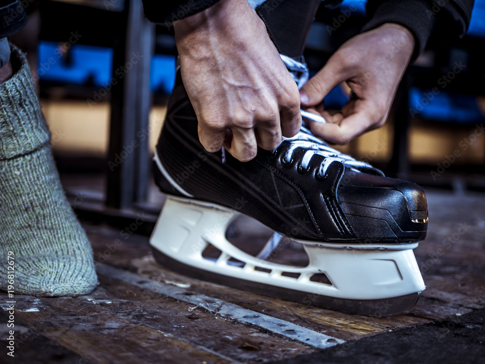 close up shot of hand tie shoelaces of ice hockey skates in locker room close up shot of hand tie shoelaces of ice hockey skates in locker room