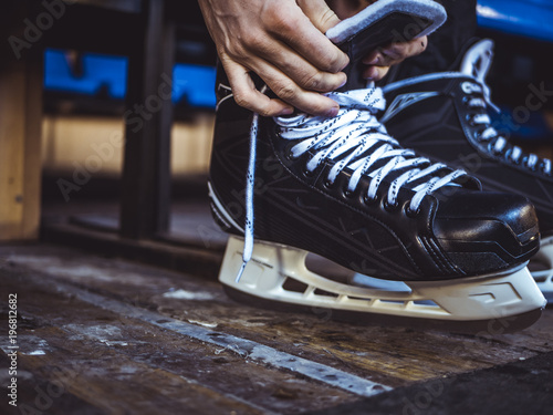 Canvas Print close up shot of hand tie shoelaces of ice hockey skates in locker room