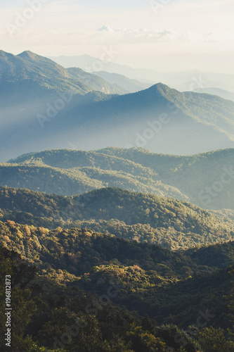Smoky mountain landscape with mountain and light rays before sunset.