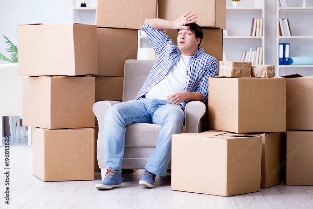 Young man moving in to new house with boxes Young man moving in to new house with boxes
