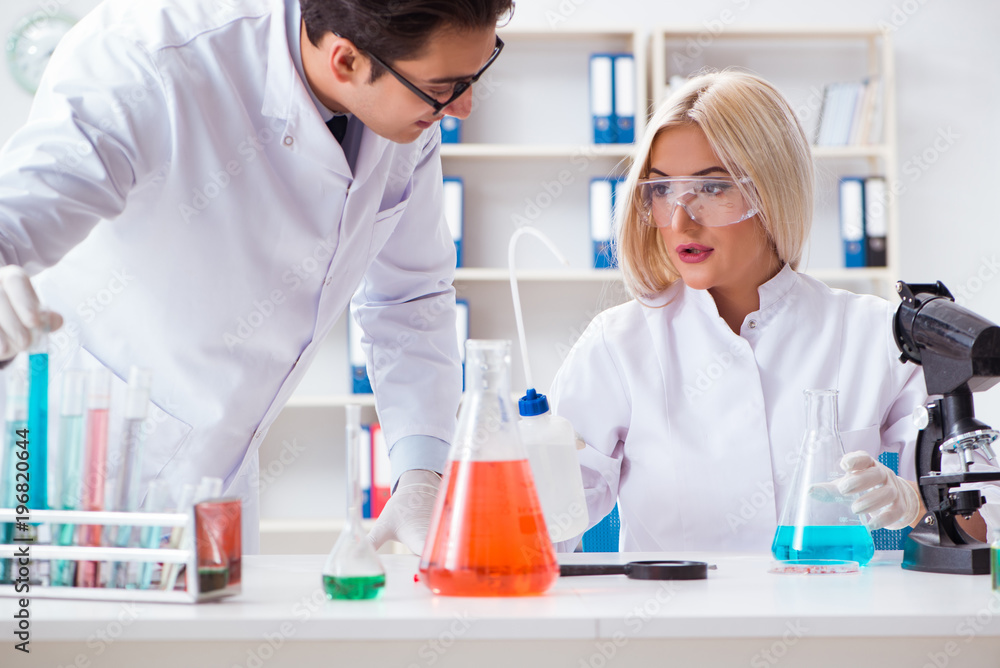 Two chemists having discussion in lab Two chemists having discussion in lab